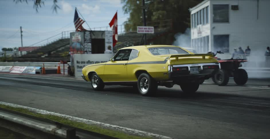 A man runs alongside a race track as a race car pulls in