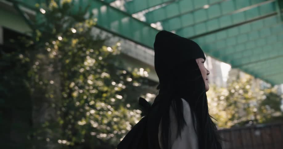 A woman walking under a bridge