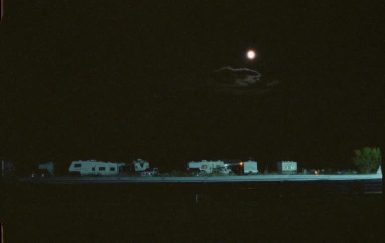 A car passes the trailers on the side of the road
