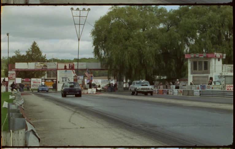 Two cars racing on a drag strip