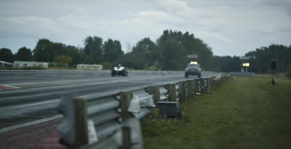 Two cars race on the track