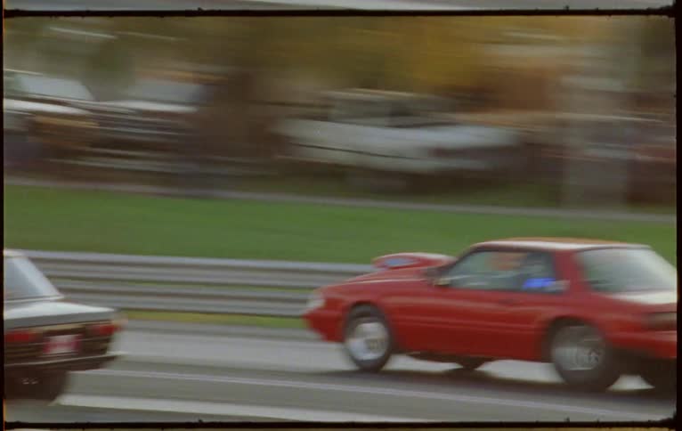 Two cars drag racing at a dragstrip