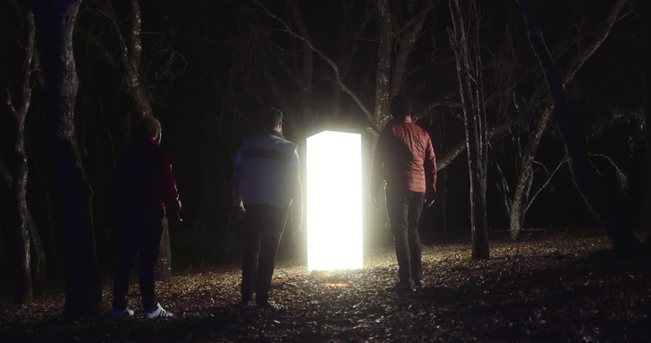 Three men are looking at a glowing obelisk in the woods