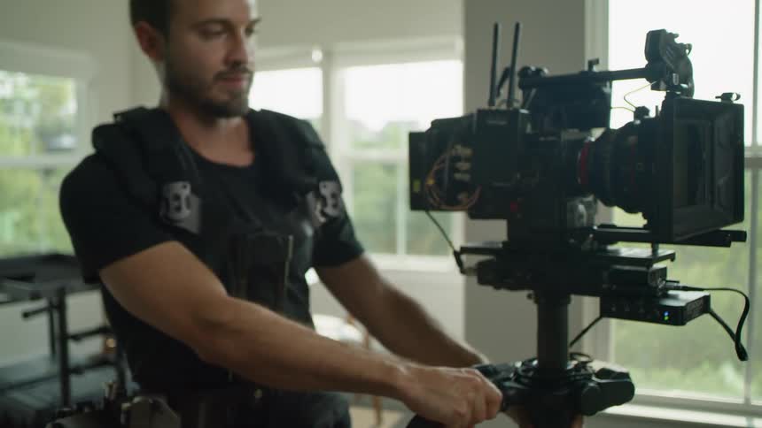 A photographer wheels his camera across a room