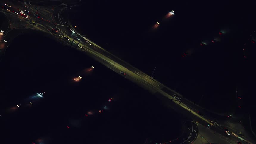 Night aerial looking down on Interstate 5 and a bridge crossing the highway in this high altitude aerial shot of the city