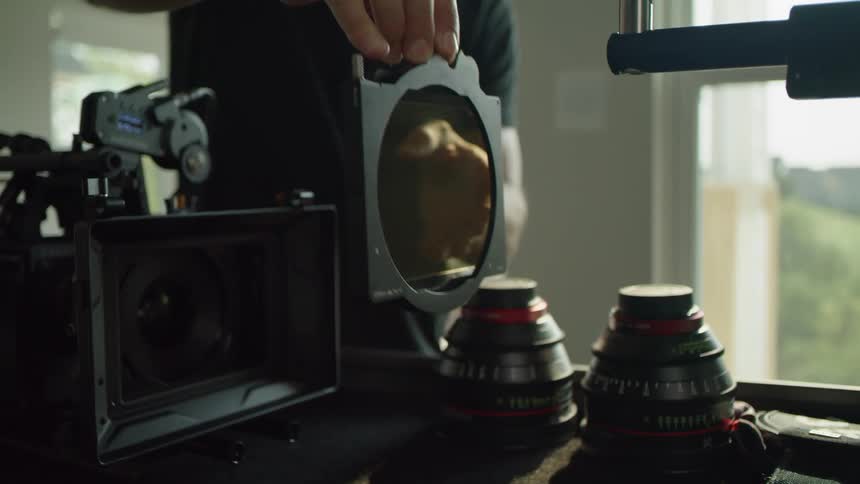 A man places a filter lens in his camera
