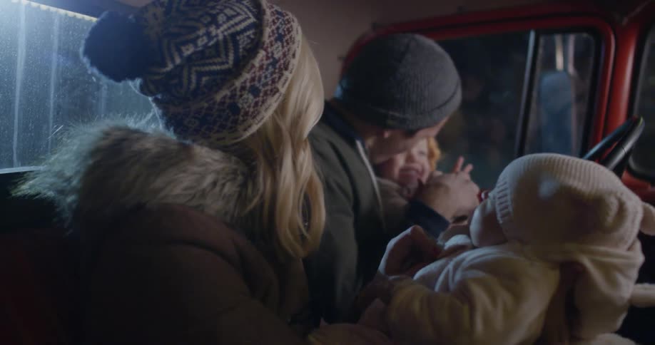 A family in an old farm truck on a winter night