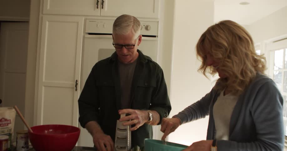 A man and woman are cooking in the kitchen