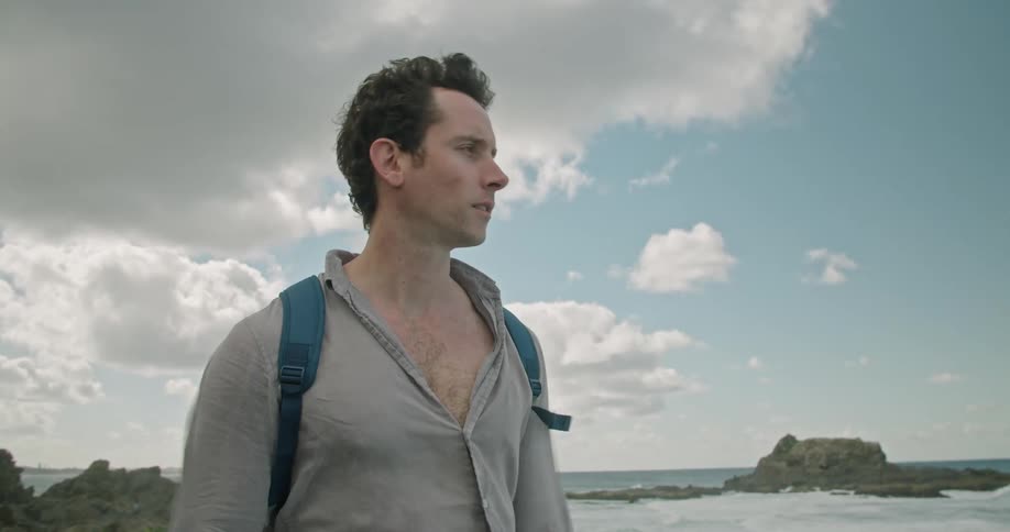 A man standing out near the ocean