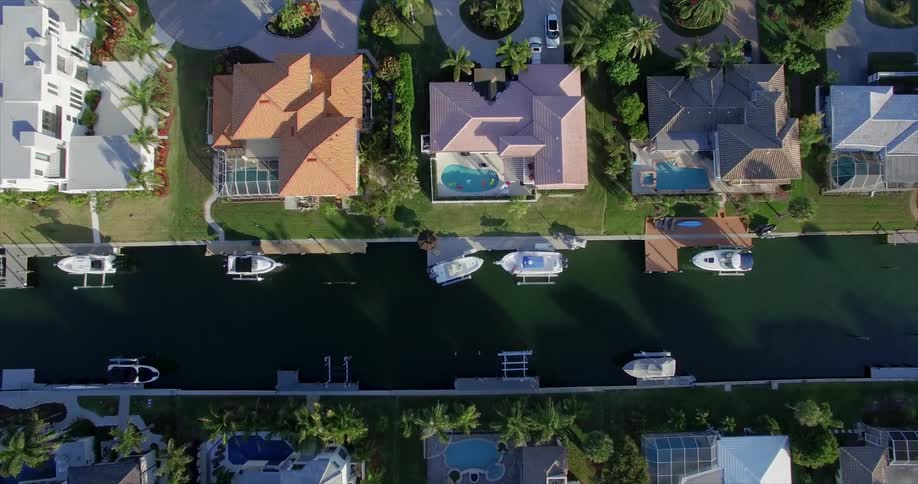 Overhead view of an affluent neighborhood with boats on their canal