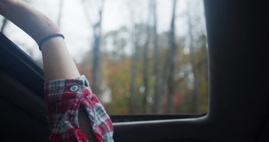 A person waves their hand through the sunroof
