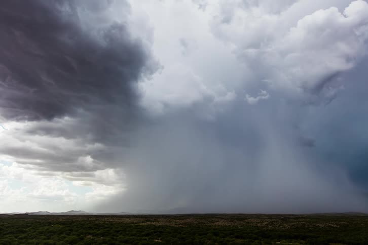 Storm clouds move quickly over an open field