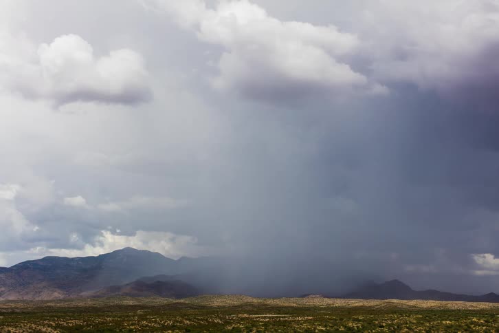 Storm clouds start spinning as they move across mountains