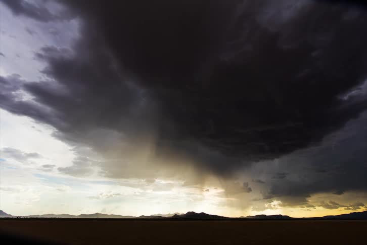 Dark storm clouds and lightning at sunset