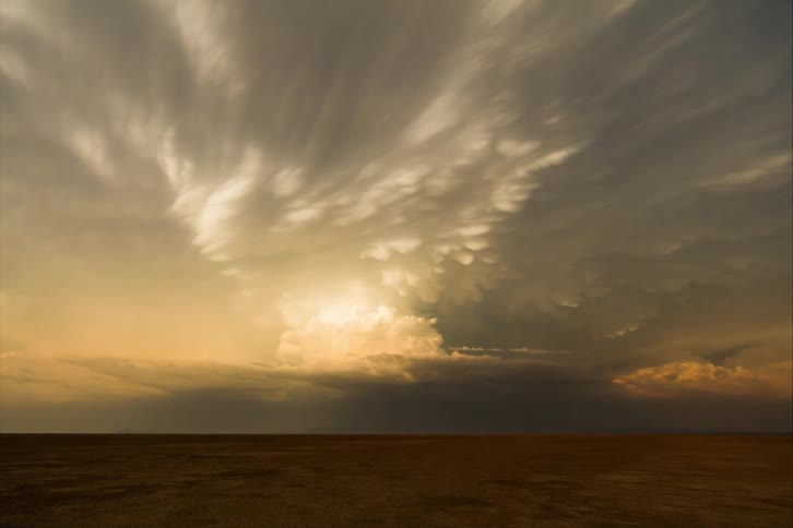 Storm clouds form over plains and start spinning as light darkens