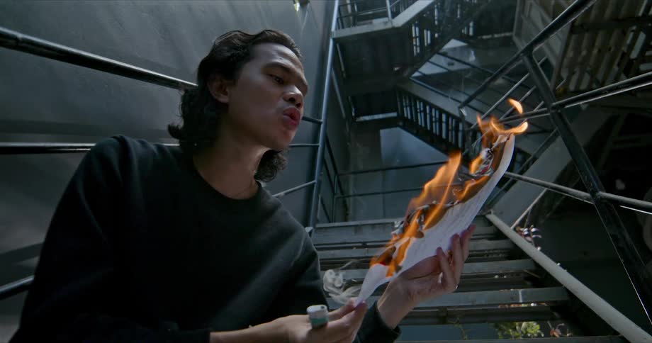 A man is standing by a staircase near an open flame