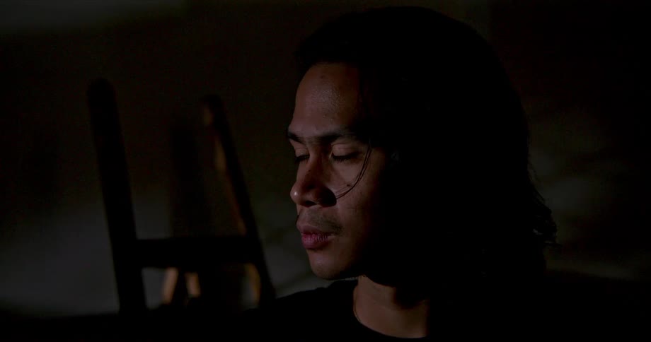 A man standing in a room with a easel in the background