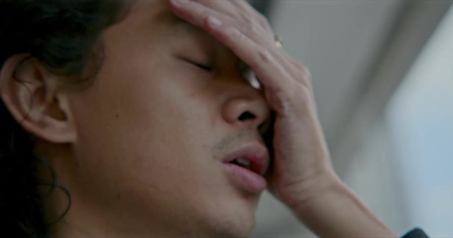 A male places his hand up to his face as he experiences disappointment