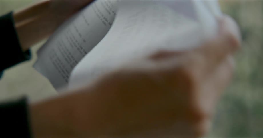 A person reading through papers they are holding