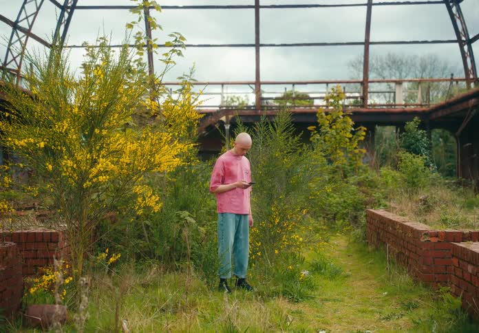 A man is using his cell phone in the garden