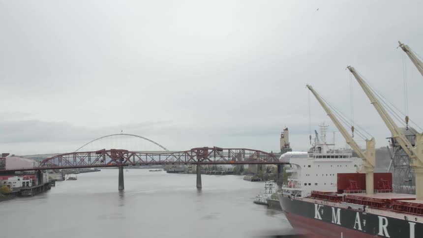 Moving across a bridge near a harbor and urban area