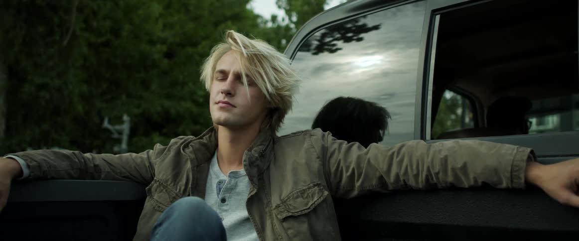 A man is riding in the back of the pickup truck