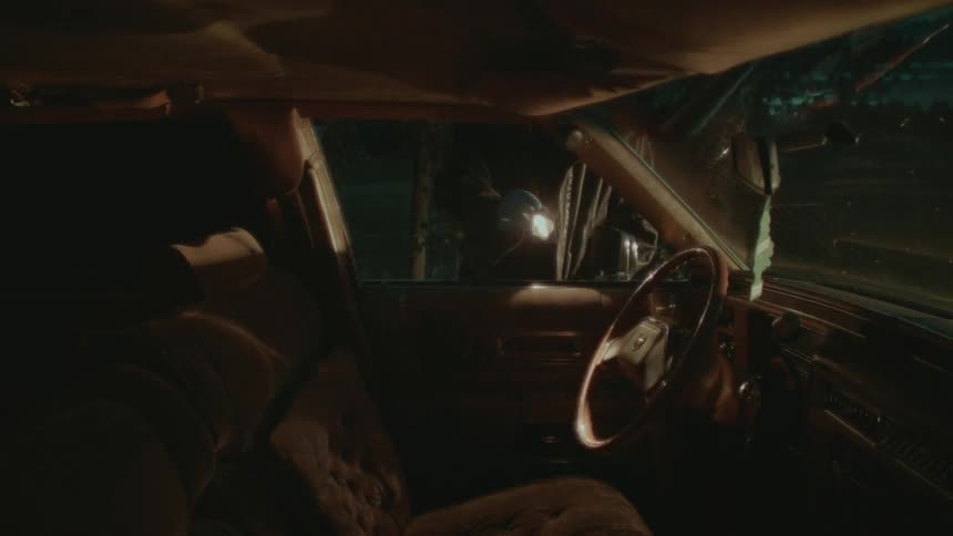 An officer searching through a car
