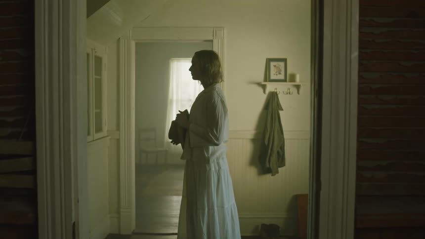 A woman is standing in a room during the day