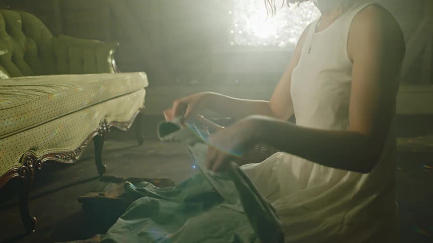 A woman looking sad and folding clothes