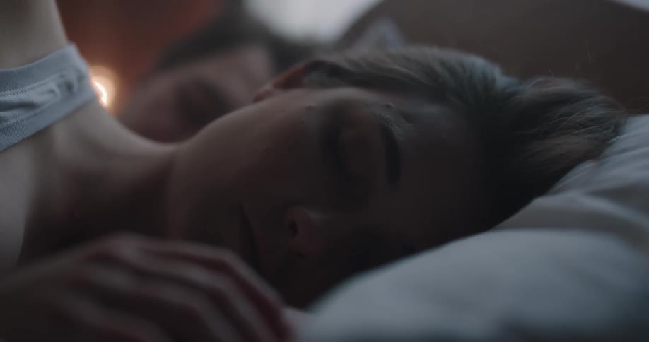 A man and woman sleeping in bed
