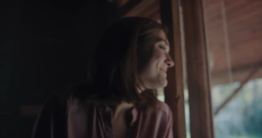 A woman smiles as she looks our her window