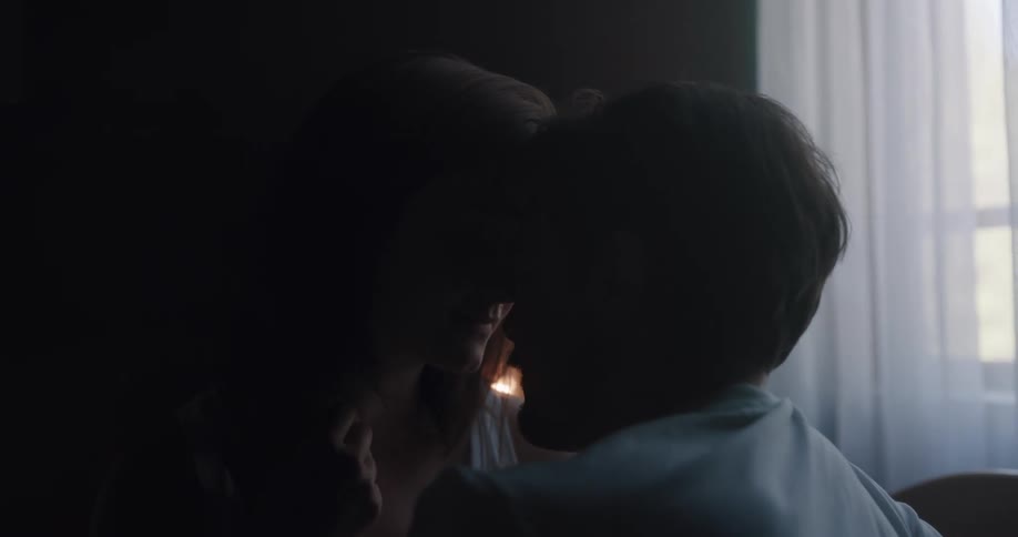 Two people kissing in a bedroom