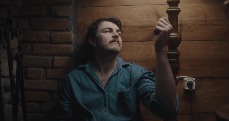 A man playing with a lamp