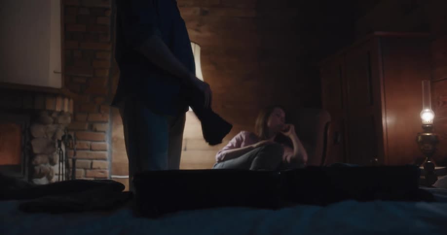 Man packing luggage over the bed in the room on a cabin