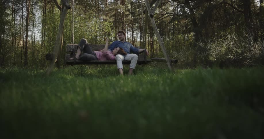 A man and woman sit on the swing together