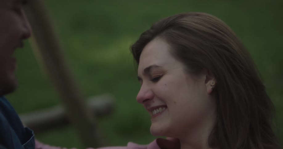 A couple are kissing on the swing