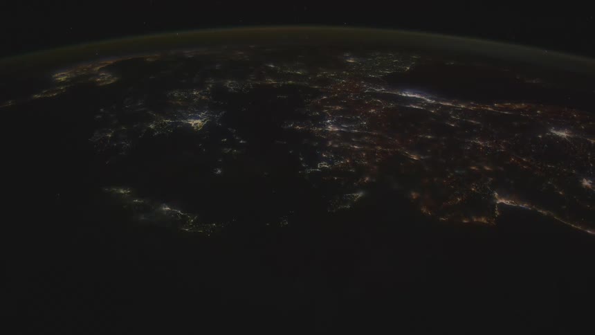 The surface of the planet earth can be seen at night from outer space