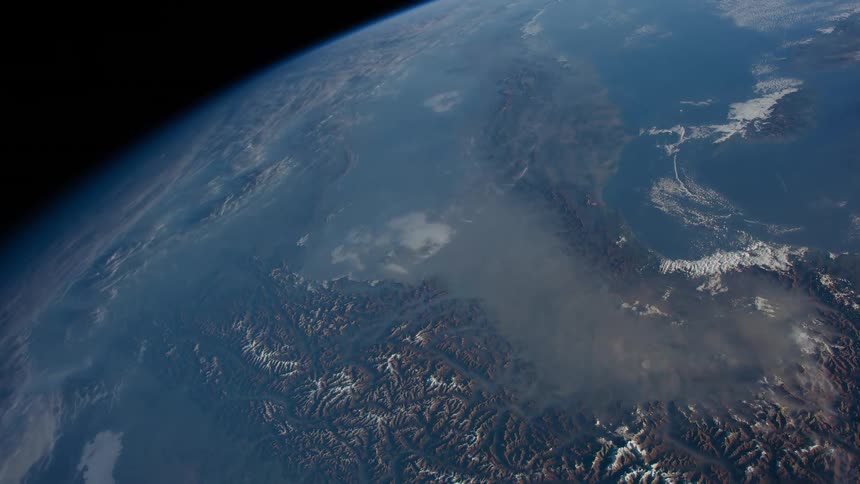 Clouds float over earth oceans and ice topped terrain
