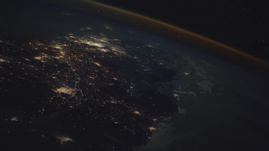 City lights glow brightly on the surface of earth from space