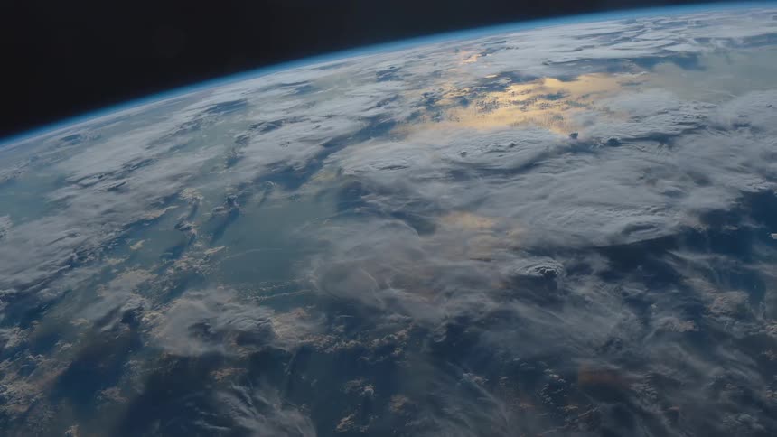 Light glows as it reflects off the curved surface of the earth in space
