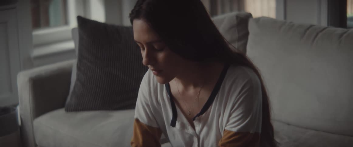 A woman sitting on a couch typing