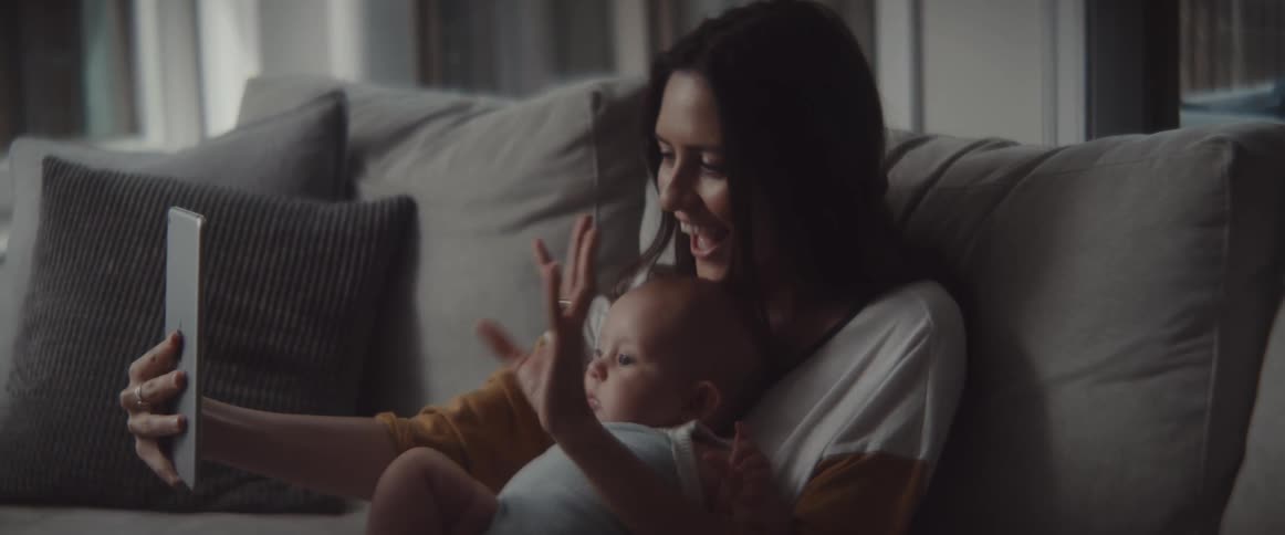 A mother and baby talking on a tablet