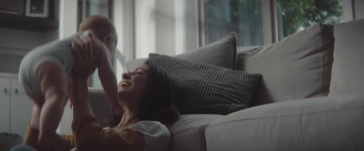A mother holding a baby in a room