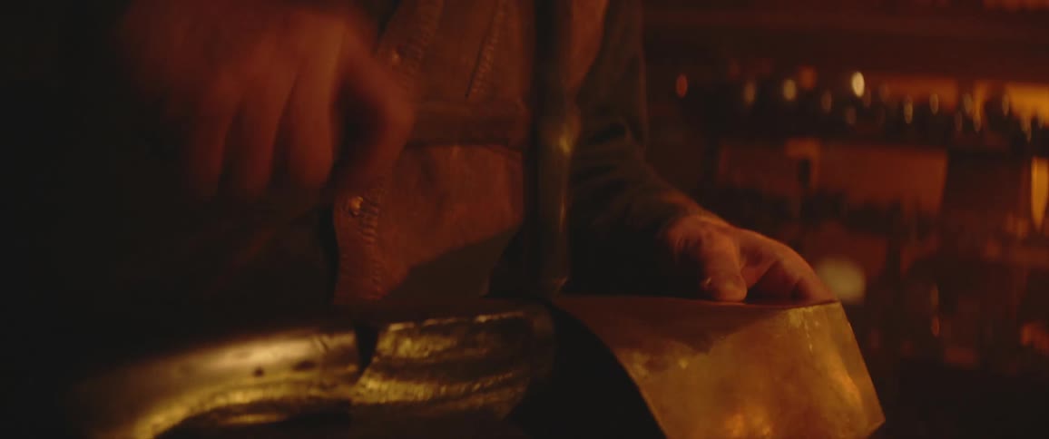 A person in a room shaping a piece of metal with an anvil and hammer
