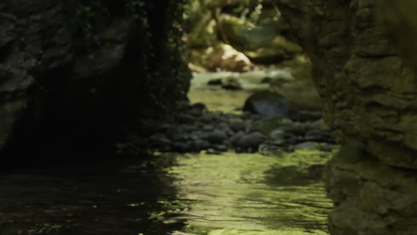 Water rushes down a stream between two rock walls