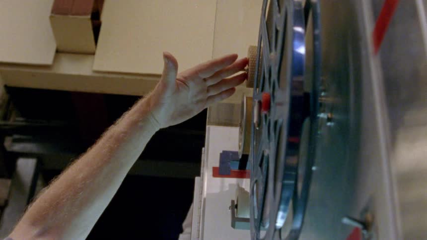 A person reaching out to a film reel