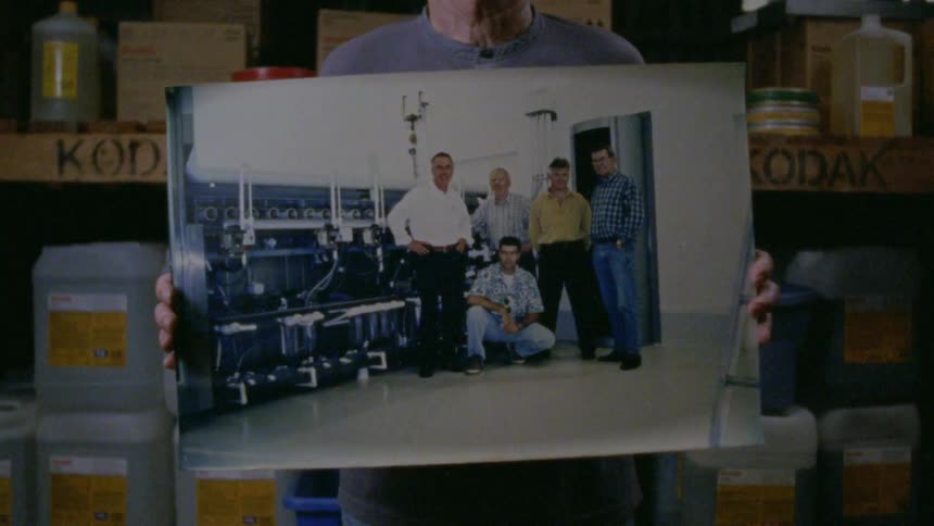 Man standing inside a warehouse showing a picture