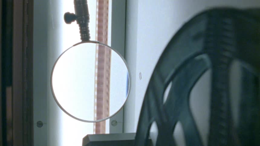 Film real spin moving series of frames past magnifying glass
