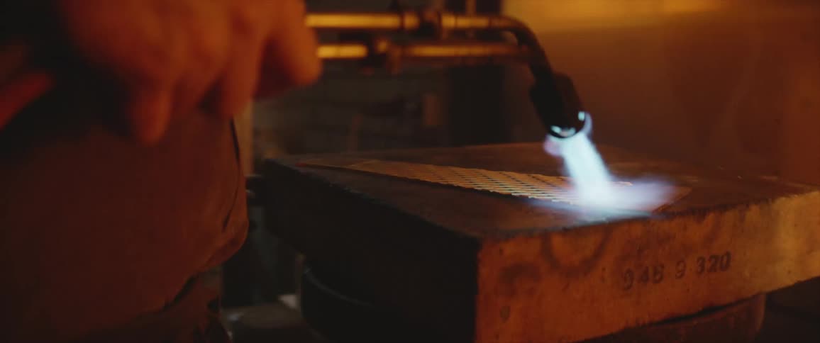 A close up of a person using a torch on metal