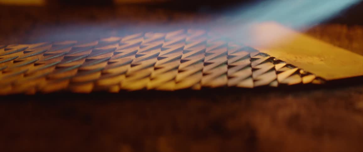 A high heat torch is used over a large piece of patterned metal